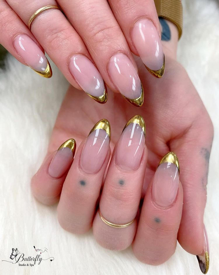 Soft nude almond nails with gold french tips