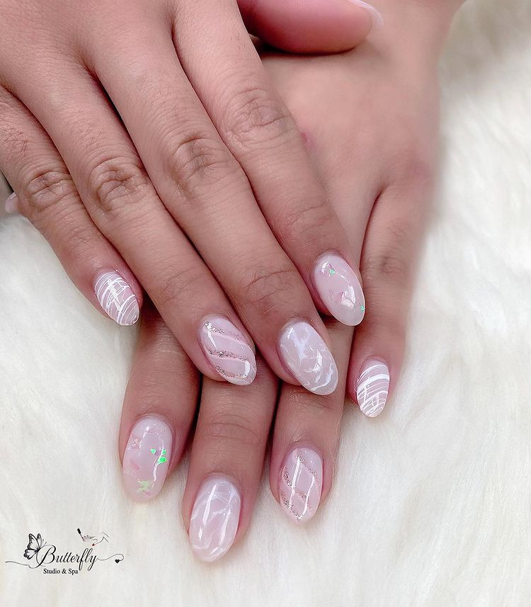 Pale pink nails with silver snowflake accents